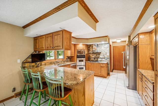 2216 146th Ave NE, Ham Lake, MN 55304 - kitchen with stainless steel appliances, wall chimney range hood, a textured ceiling, backsplash, and a peninsula