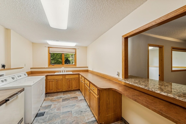 2216 146th Ave NE, Ham Lake, MN 55304 - laundry area with a textured ceiling, separate washer and dryer, cabinet space, and stone finish floors