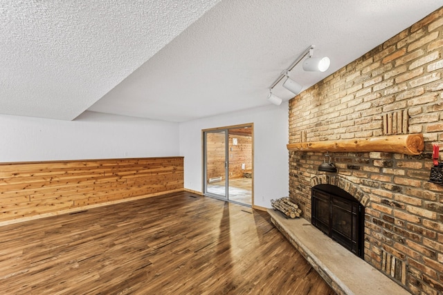 2216 146th Ave NE, Ham Lake, MN 55304 - unfurnished living room with wood finished floors, a textured ceiling, a fireplace, and rail lighting