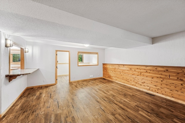 2216 146th Ave NE, Ham Lake, MN 55304 - unfurnished room featuring wood finished floors and a textured ceiling