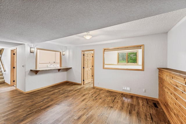 2216 146th Ave NE, Ham Lake, MN 55304 - unfurnished living room featuring wood finished floors, stairway, and a textured ceiling