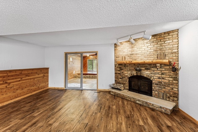 2216 146th Ave NE, Ham Lake, MN 55304 - unfurnished living room with track lighting, wood finished floors, a textured ceiling, and a fireplace