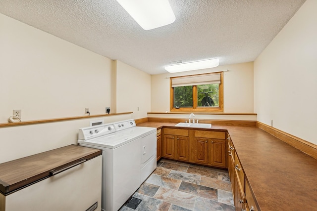 2216 146th Ave NE, Ham Lake, MN 55304 - laundry room with washer and dryer, a textured ceiling, light stone finish floors, and cabinet space