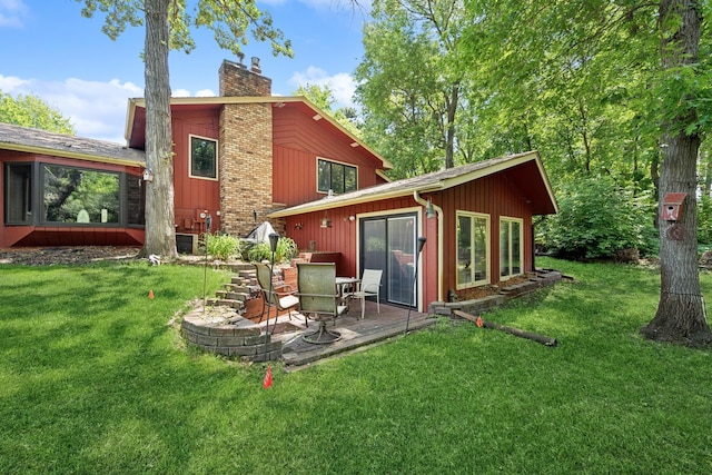 2216 146th Ave NE, Ham Lake, MN 55304 - rear view of house featuring a chimney, a lawn, and a wooden deck