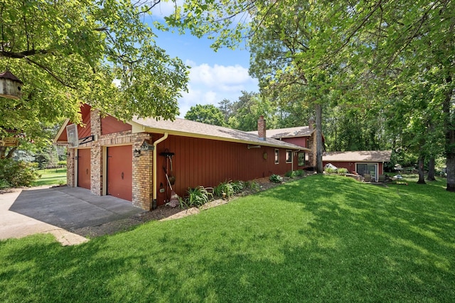 2216 146th Ave NE, Ham Lake, MN 55304 - view of side of property with a chimney, a yard, driveway, an attached garage, and brick siding