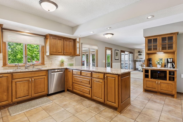 15905 43rd Ave N, Plymouth, MN 55446 - kitchen with stainless steel dishwasher, a sink, a peninsula, brown cabinetry, and a textured ceiling