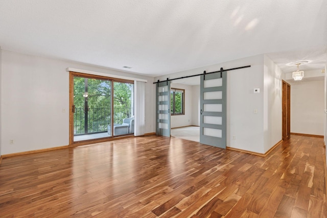 20 Windsor Ln Unit 213A, New Brighton, MN 55112 - spare room with a barn door, light wood finished floors, and baseboards