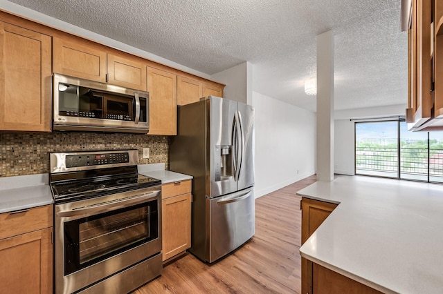 26 10th St W Unit 1108, Saint Paul, MN 55102 - kitchen with stainless steel appliances, tasteful backsplash, light countertops, light wood finished floors, and a textured ceiling