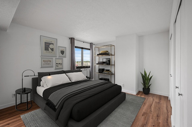 26 10th St W Unit 1108, Saint Paul, MN 55102 - bedroom with a textured ceiling, baseboards, and wood finished floors