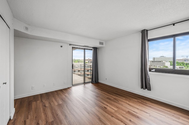 26 10th St W Unit 1108, Saint Paul, MN 55102 - spare room with a textured ceiling, wood finished floors, and baseboards