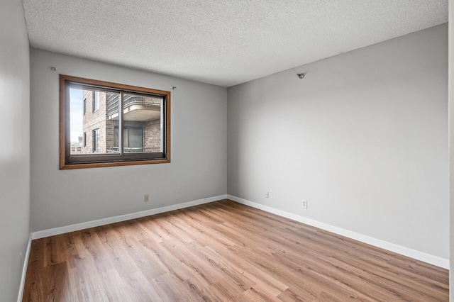 26 10th St W Unit 1108, Saint Paul, MN 55102 - spare room featuring wood finished floors, a textured ceiling, and baseboards
