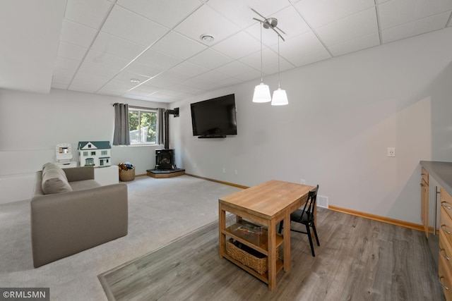 2119 13th Ave E, North Saint Paul, MN 55109 - living room featuring a wood stove, a drop ceiling, and wood finished floors