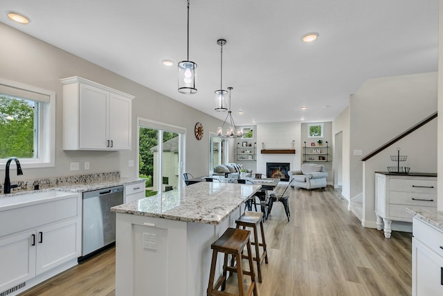 1715 Par Ln, Buffalo, MN 55313 - kitchen with stainless steel dishwasher, a sink, white cabinetry, open floor plan, and a kitchen bar
