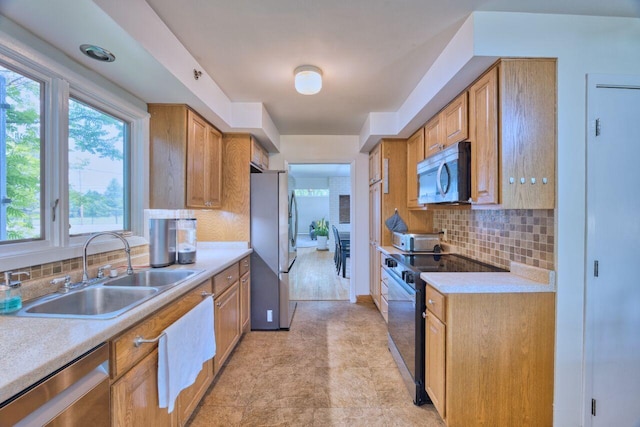 417 Main St S, Aurora, MN 55705 - kitchen with appliances with stainless steel finishes, backsplash, light countertops, and brown cabinetry