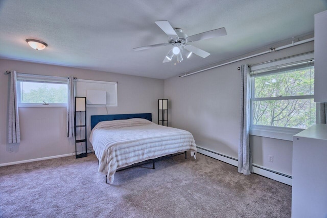 417 Main St S, Aurora, MN 55705 - carpeted bedroom with multiple windows, a baseboard radiator, and a ceiling fan