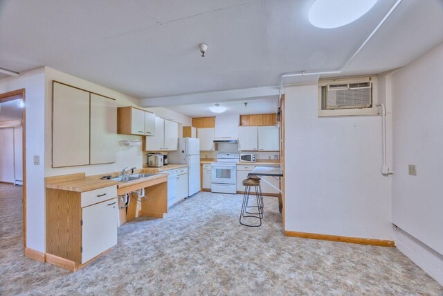 417 Main St S, Aurora, MN 55705 - kitchen featuring white appliances, light countertops, light colored carpet, an AC wall unit, and under cabinet range hood