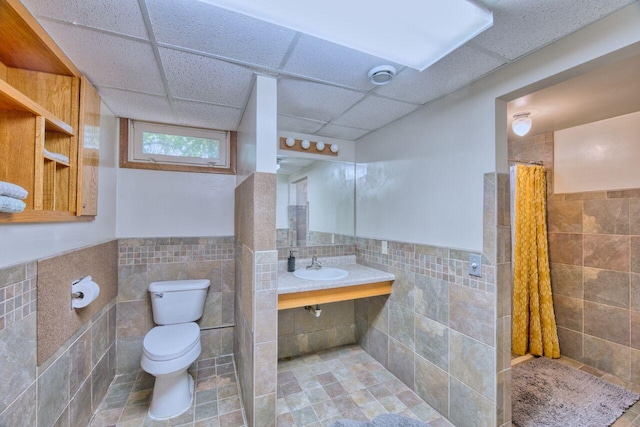 417 Main St S, Aurora, MN 55705 - full bath featuring tile walls, a paneled ceiling, tiled shower, wainscoting, and tile patterned flooring