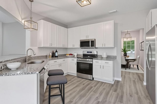 1418 Bluff St, Dundas, MN 55019 - kitchen with stainless steel appliances, light stone counters, white cabinetry, and tasteful backsplash