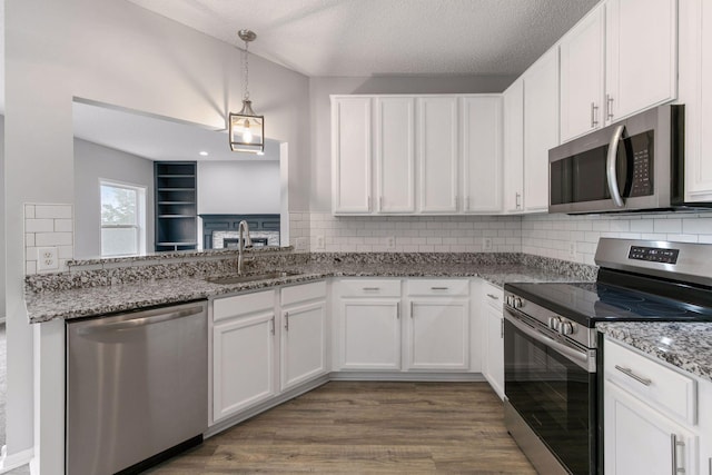 1418 Bluff St, Dundas, MN 55019 - kitchen with stainless steel appliances, white cabinets, a textured ceiling, decorative backsplash, and hanging light fixtures