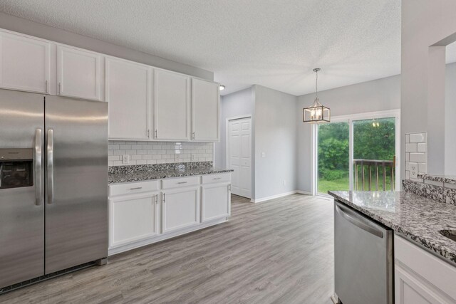 1418 Bluff St, Dundas, MN 55019 - kitchen featuring appliances with stainless steel finishes, white cabinetry, light wood finished floors, light stone counters, and a textured ceiling