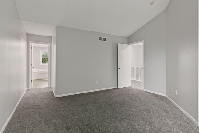 1418 Bluff St, Dundas, MN 55019 - unfurnished bedroom featuring dark colored carpet, lofted ceiling, and connected bathroom