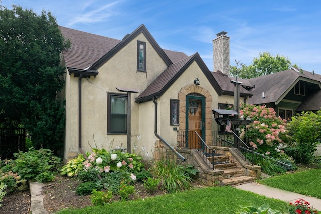 241 Queen Ave S, Minneapolis, MN 55405 - english style home featuring stucco siding, a chimney, and a shingled roof