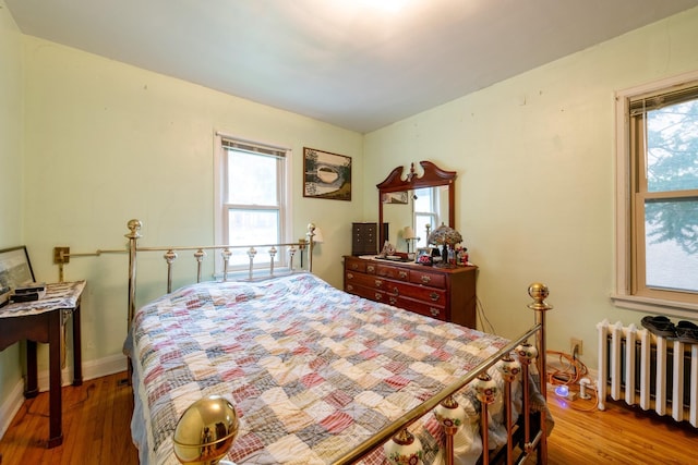 241 Queen Ave S, Minneapolis, MN 55405 - bedroom with radiator heating unit, wood finished floors, and baseboards