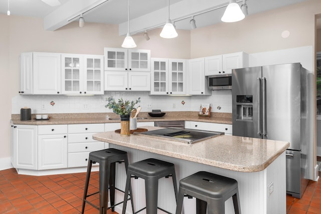 1101 Skyline Pkwy, Duluth, MN 55805 - kitchen featuring track lighting, appliances with stainless steel finishes, tasteful backsplash, a breakfast bar area, and white cabinets
