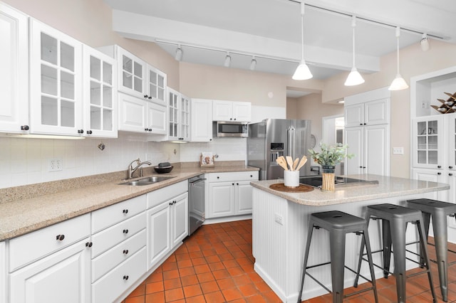 1101 Skyline Pkwy, Duluth, MN 55805 - kitchen featuring stainless steel appliances, rail lighting, a sink, a breakfast bar area, and decorative backsplash