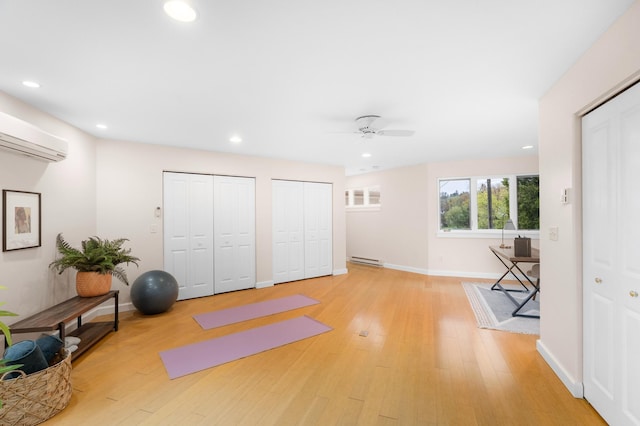 1101 Skyline Pkwy, Duluth, MN 55805 - workout room with baseboard heating, a wall mounted AC, ceiling fan, recessed lighting, and light wood-style floors