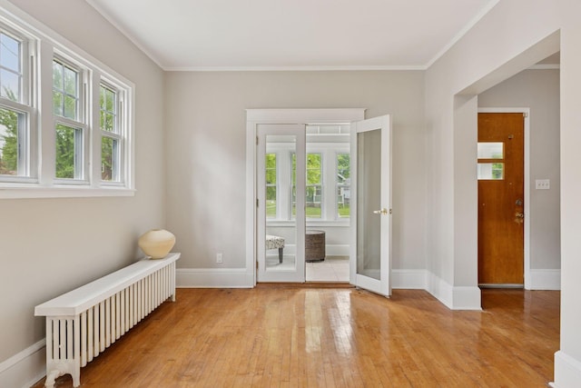 1418 Payne Ave, Saint Paul, MN 55130 - spare room with radiator heating unit, light wood-type flooring, and ornamental molding