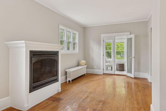 1418 Payne Ave, Saint Paul, MN 55130 - living room with radiator heating unit, light wood-style flooring, crown molding, and a fireplace