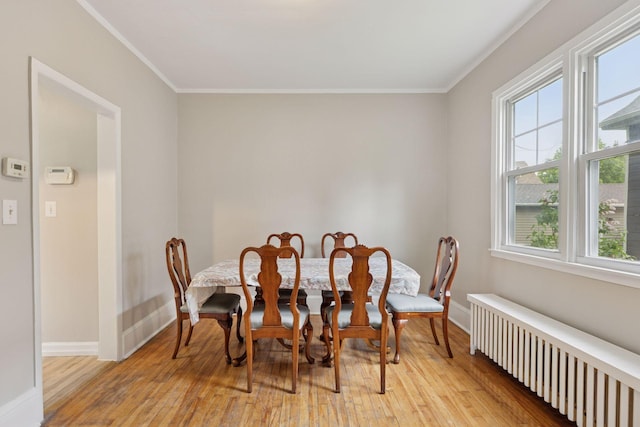 1418 Payne Ave, Saint Paul, MN 55130 - dining area with radiator, light wood-style floors, and ornamental molding