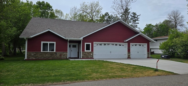 6207 Lagoon Dr NE, Bemidji, MN 56601 - ranch-style house with concrete driveway, an attached garage, a front yard, roof with shingles, and stone siding