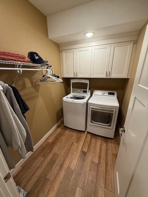 6207 Lagoon Dr NE, Bemidji, MN 56601 - laundry room with cabinet space, washing machine and dryer, light wood-style floors, and baseboards