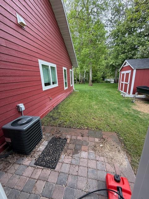 6207 Lagoon Dr NE, Bemidji, MN 56601 - view of grassy yard featuring central air condition unit and a patio