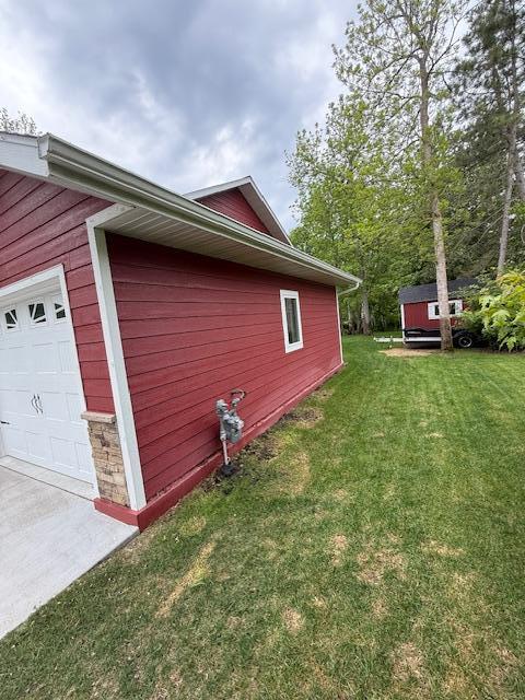 6207 Lagoon Dr NE, Bemidji, MN 56601 - view of property exterior featuring a garage and a yard