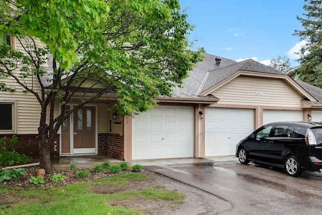 6251 Magda Dr Unit B, Maple Grove, MN 55369 - view of front of property featuring an attached garage, brick siding, a shingled roof, and asphalt driveway