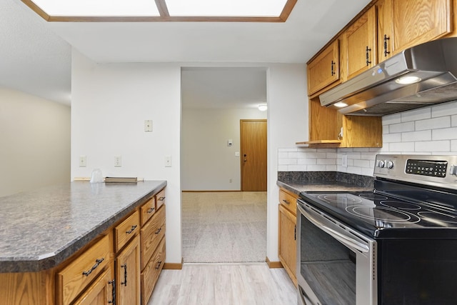 6251 Magda Dr Unit B, Maple Grove, MN 55369 - kitchen featuring stainless steel electric range, under cabinet range hood, dark countertops, brown cabinetry, and tasteful backsplash