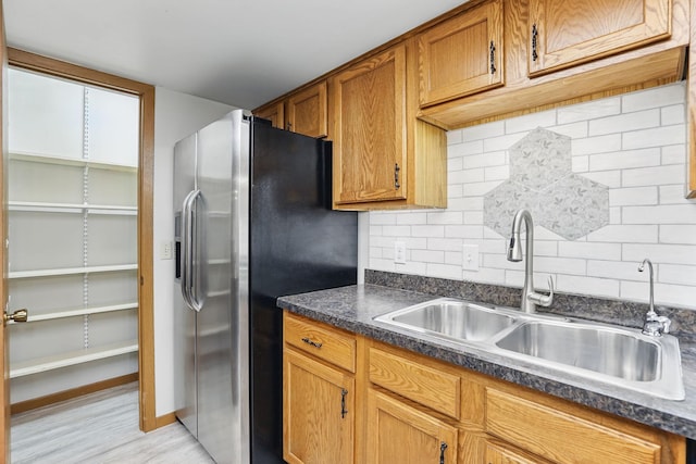 6251 Magda Dr Unit B, Maple Grove, MN 55369 - kitchen with a sink, stainless steel fridge, dark countertops, brown cabinetry, and decorative backsplash