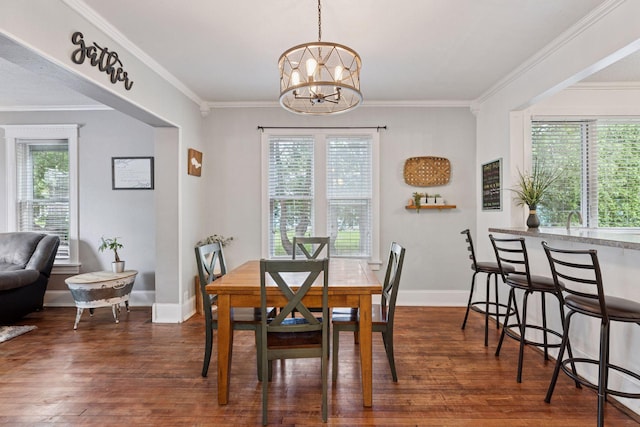 332 2nd St, New Richmond, WI 54017 - dining space featuring dark wood finished floors, a chandelier, crown molding, and baseboards