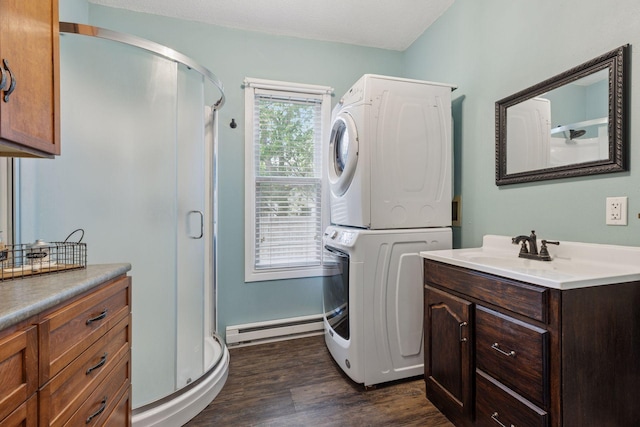 332 2nd St, New Richmond, WI 54017 - bathroom featuring a baseboard heating unit, stacked washer / dryer, a shower stall, vanity, and wood finished floors