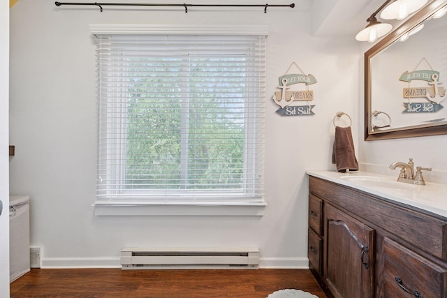 332 2nd St, New Richmond, WI 54017 - bathroom with baseboard heating, vanity, wood finished floors, and baseboards