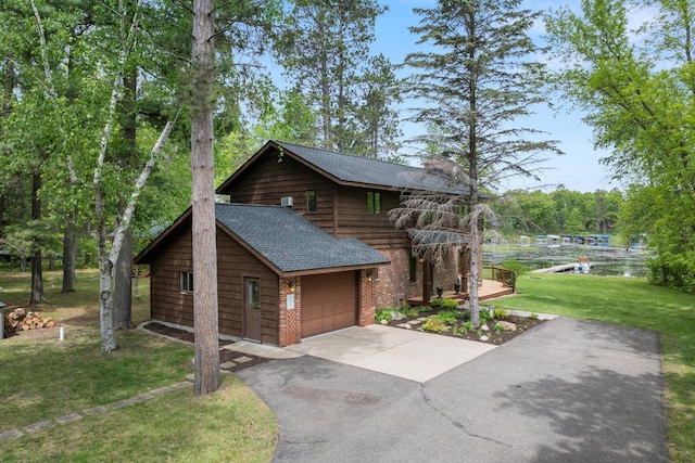 11690 Harbor Ln, Ideal Twp, MN 56442 - view of side of property with a shingled roof, driveway, a garage, a lawn, and brick siding
