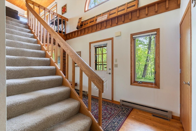 11690 Harbor Ln, Ideal Twp, MN 56442 - entrance foyer featuring a baseboard heating unit, wood finished floors, stairs, baseboards, and a baseboard radiator