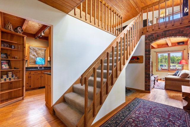 11690 Harbor Ln, Ideal Twp, MN 56442 - stairway featuring wooden ceiling with exposed beams, wood finished floors, arched walkways, and baseboards