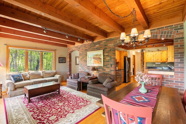 11690 Harbor Ln, Ideal Twp, MN 56442 - living area featuring wood finished floors, rail lighting, wooden ceiling with exposed beams, brick wall, and a chandelier