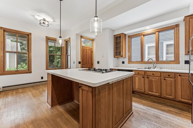 492 Dayton Ave, Saint Paul, MN 55102 - kitchen with gas cooktop, a baseboard radiator, brown cabinetry, light wood-style floors, and decorative backsplash