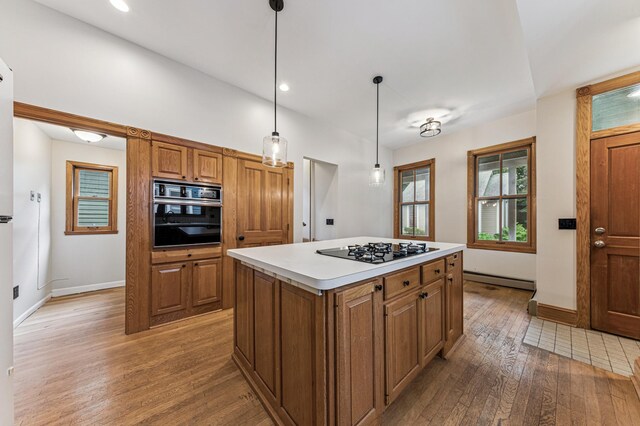492 Dayton Ave, Saint Paul, MN 55102 - kitchen with black appliances, light wood finished floors, brown cabinetry, a center island, and light countertops