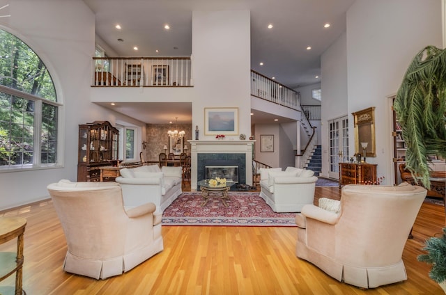 6323 Timber Trl, Edina, MN 55439 - living room featuring a high ceiling, wood finished floors, stairway, a high end fireplace, and recessed lighting
